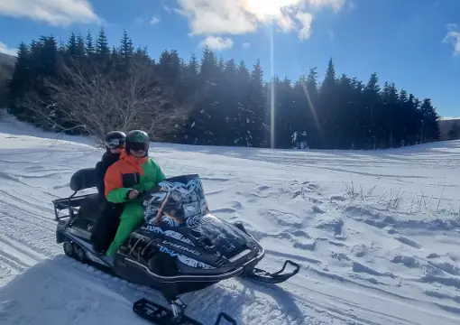 Two people sharing one snowmobile on the standard route