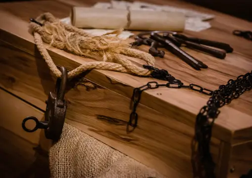 Keys, ropes and chains on a wooden chest in The Trap
