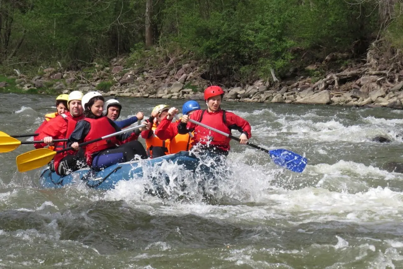 Crew in red jackets paddling through a rapid in the Iskar Gorge