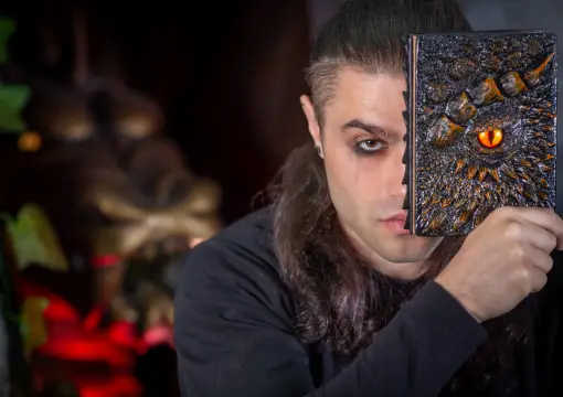 Player holding an old book with a dragon eye in the Bulgarian folklore escape room