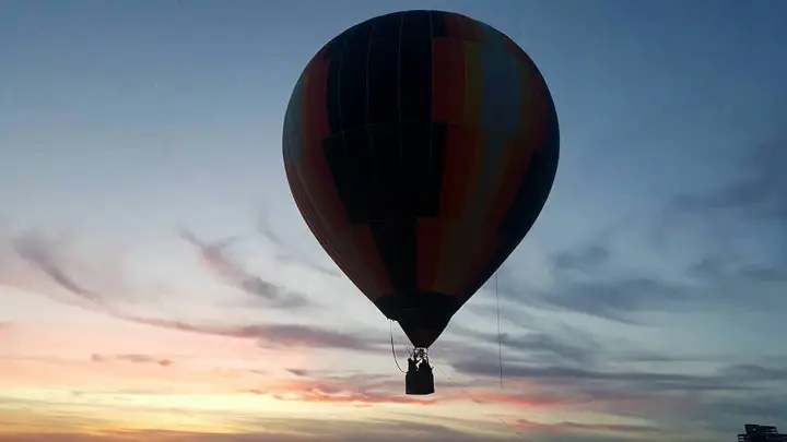 Hot air balloon against a pink sunrise sky