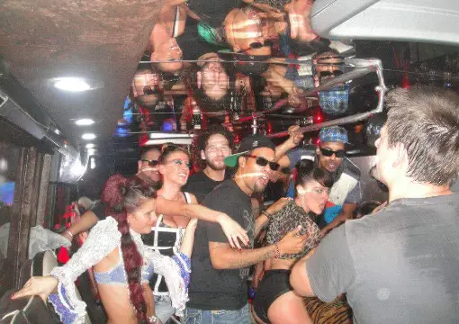 Birthday group celebrating on the party bus at night