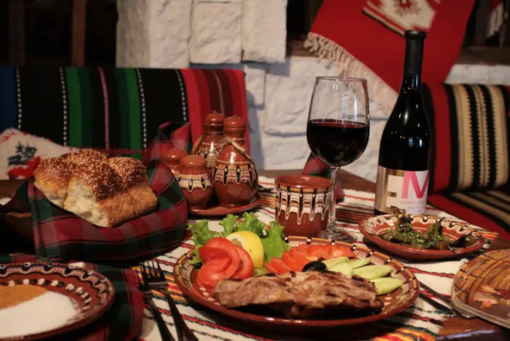 Roast meat, salads and red wine on a traditional table