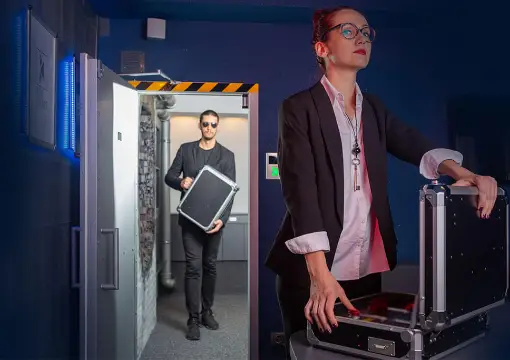 Agent with a briefcase in front of the vault door in the BOOM! Room