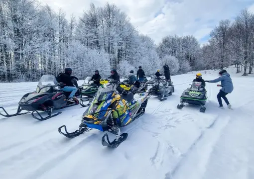 Snowmobiles in a snowy forest clearing in Stara Planina