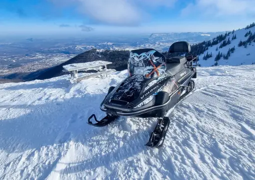 Snowmobile parked on the Petrohan ridge with views towards Sofia