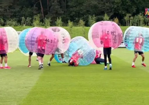 Players in pink and blue bubbles lined up on a football pitch