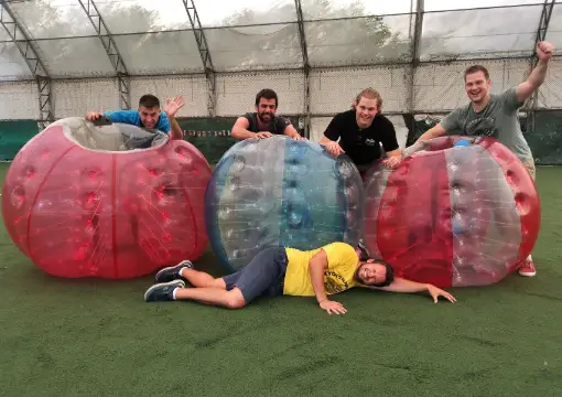 Players lying on artificial grass with bubbles under the dome