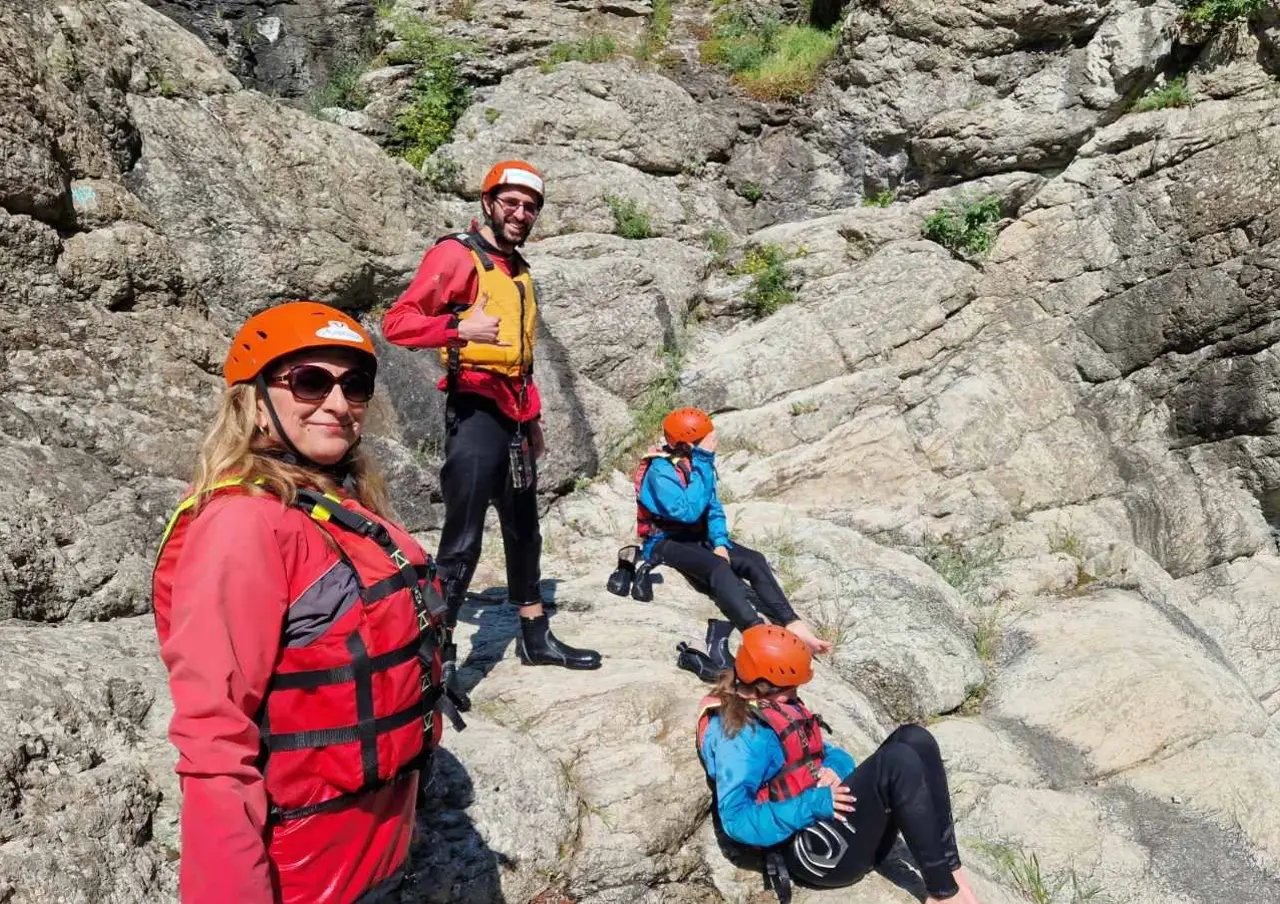 Group in helmets and life jackets on the rocks above Kazanite