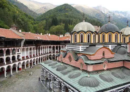 Domes of the Rila Monastery church with the mountains behind
