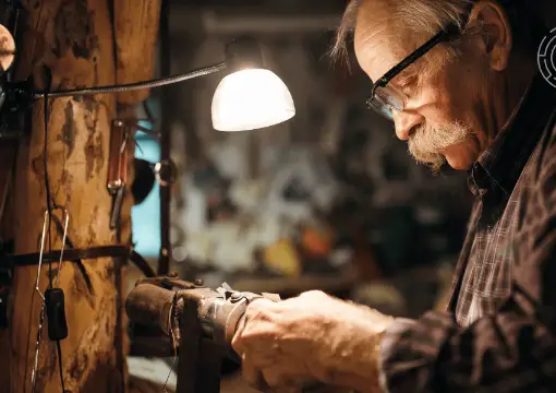The old toy master repairing a toy under his lamp
