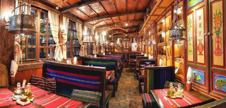 A long hall with benches covered in rugs