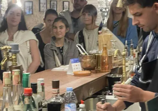 Guide pouring rakia for a group at the museum bar