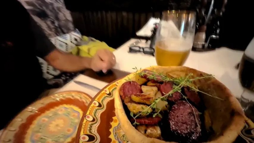 A clay plate of Bulgarian food with draft beer