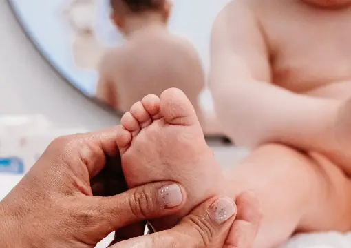 Therapist holding a baby's foot during a baby massage