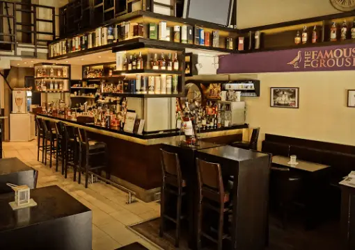Long bar at Caldo with shelves full of whisky bottles
