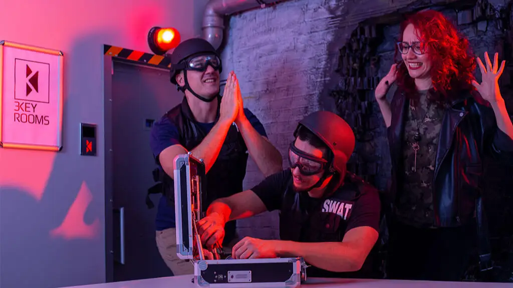 Team in safety goggles working on the bomb in the BOOM! Room escape room in Sofia