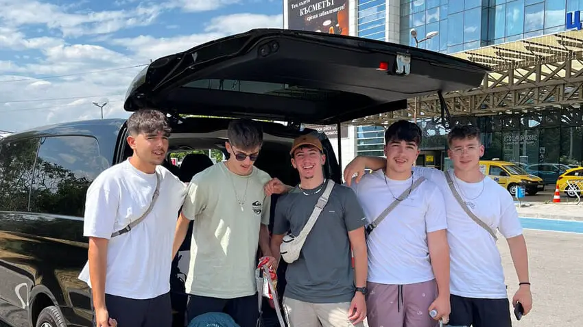 Group of friends with their bags next to a Mercedes van at Sofia Airport