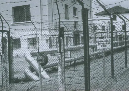Archive photo of barbed wire and camp buildings