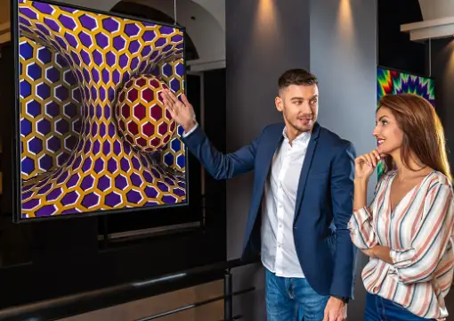 Couple in front of a spinning spiral illusion at the Museum of Illusions Sofia