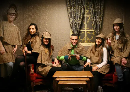 Team in detective hats in the Victorian study escape room in Sofia