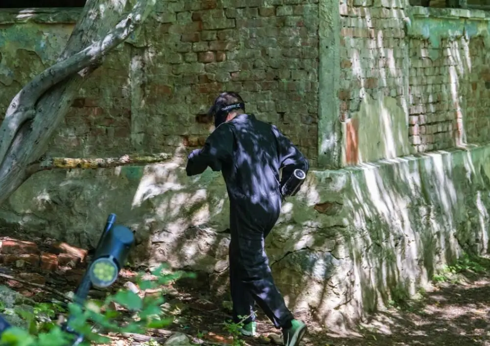 Player running for cover behind an old wall on the forest field