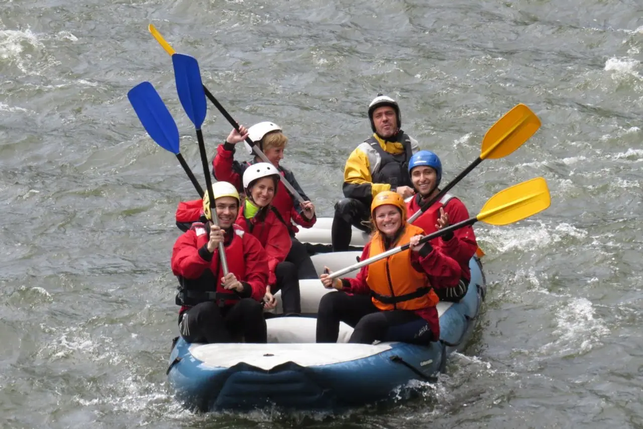 Family crew raising their paddles in a raft on the Iskar