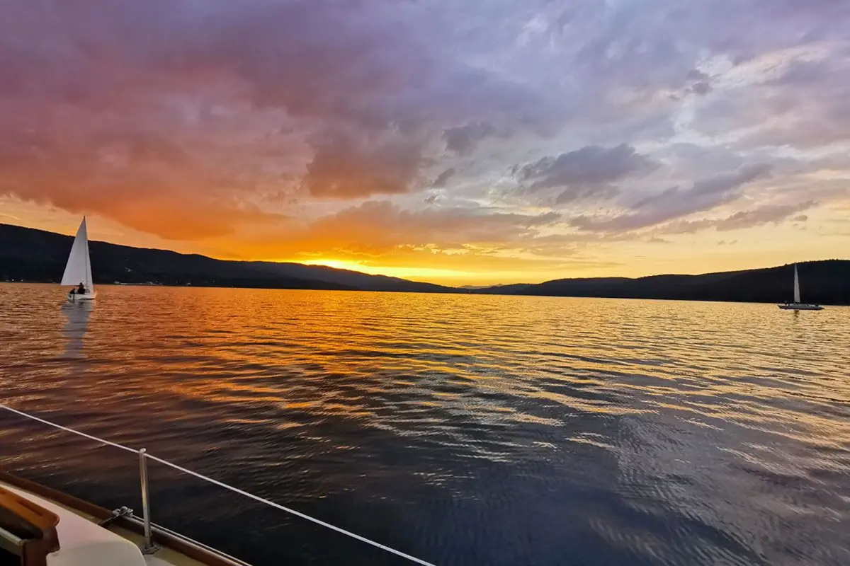 Orange sunset sky over the reservoir from a yacht deck