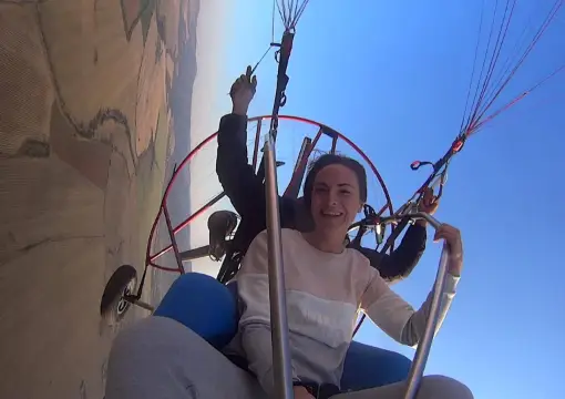 Guest waving from the trike under the paraglider wing