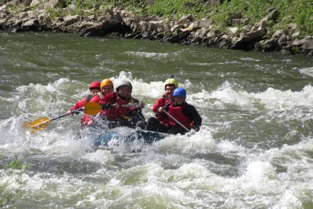 Crew in helmets riding a wave on the Iskar river