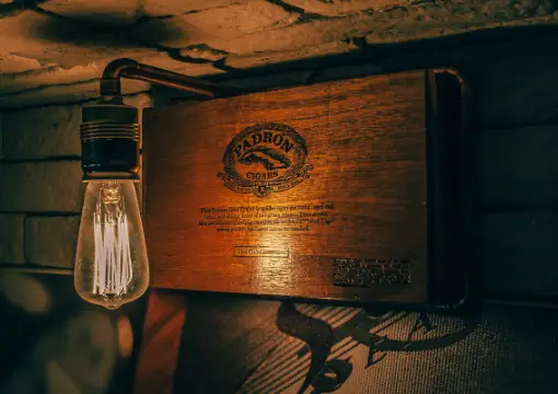 Edison bulb above a wooden cigar box at the bar