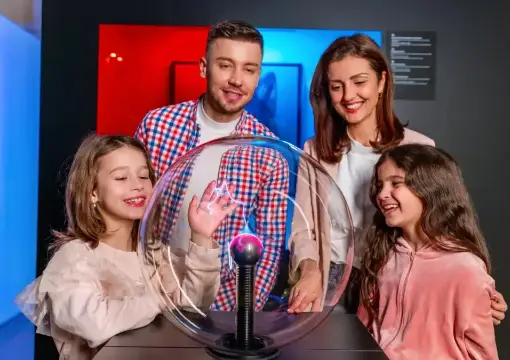 Family around the plasma globe in the physics section