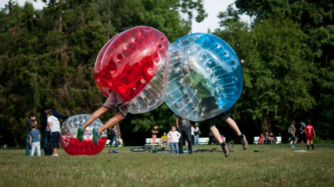 Two bubble football players colliding on a grass pitch in Sofia