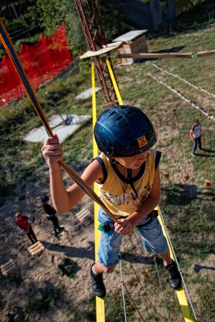 Young climber on a balance beam in the rope garden