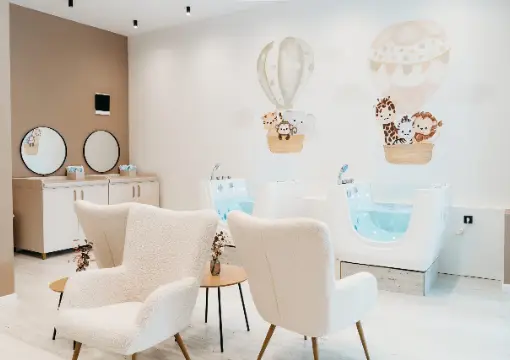 Bright treatment room with float tubs and armchairs for parents at DISI baby spa in Sofia