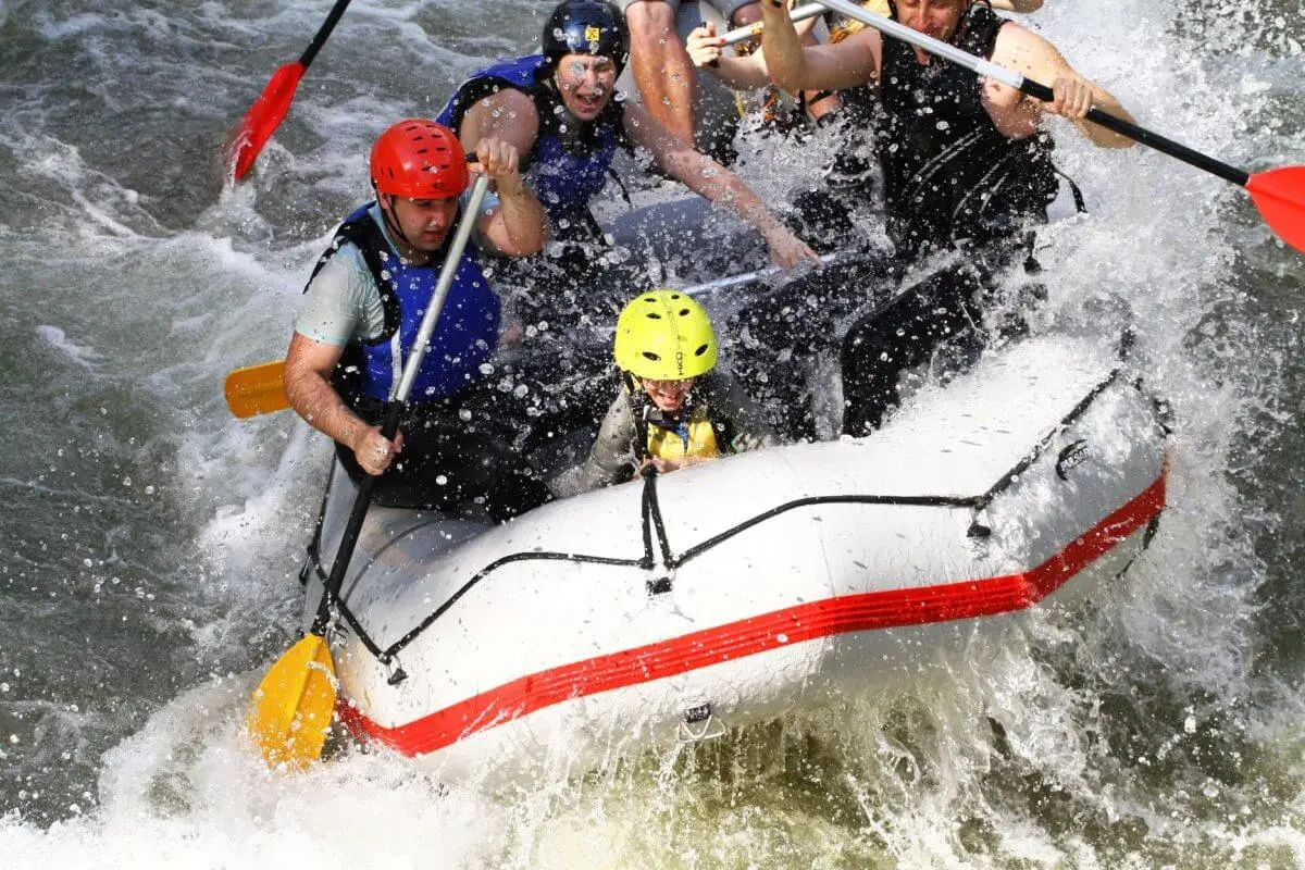 Child in a yellow helmet rafting with the family