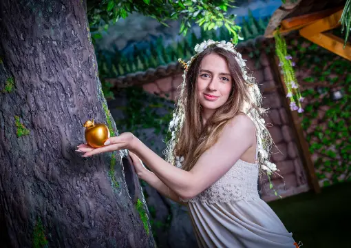 Girl under a tree with the golden apple in the escape room garden