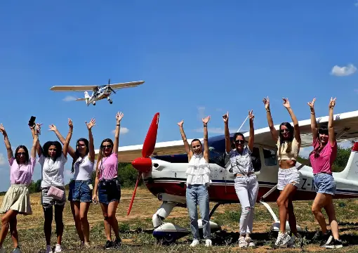 Friends cheering on the airfield as the plane flies overhead