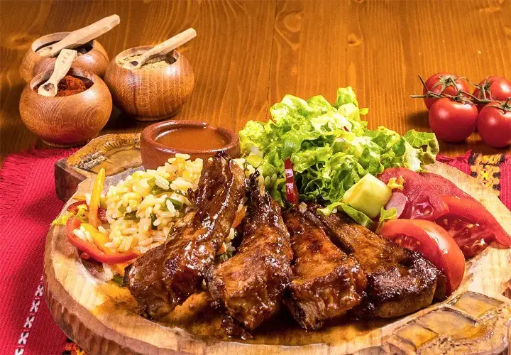 Grilled lamb cutlets with salad on a wooden board