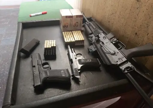 Pistols, a rifle and ammunition ready on the bench