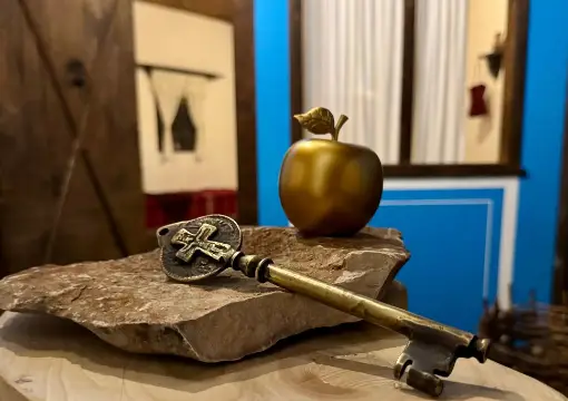 Golden apple and an old key on a stone in the escape room