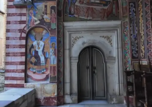 Frescoes beside a carved door at Rila Monastery
