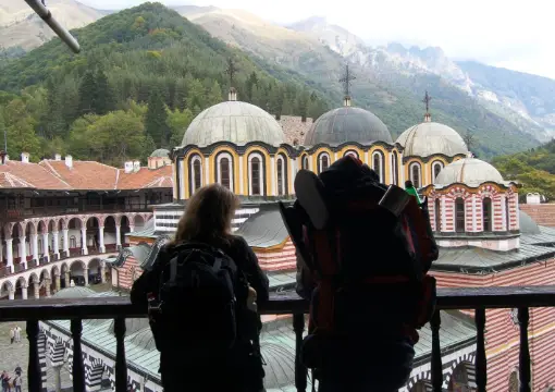 Visitors looking at the Rila Monastery church from a balcony