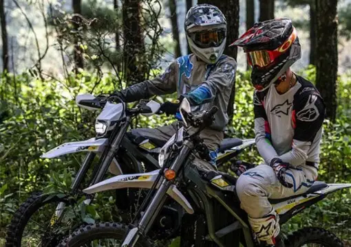 Two riders on Sur-Ron electric motorbikes in a forest near Sofia