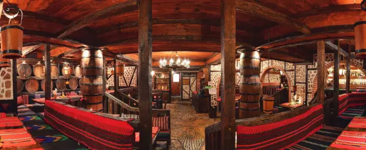 A hall with barrels and wooden pillars