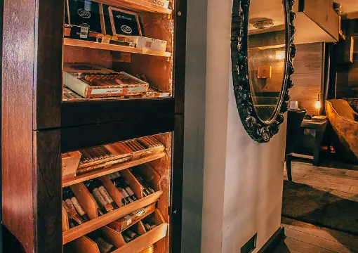Walk-in cigar humidor next to the armchairs at Caldo