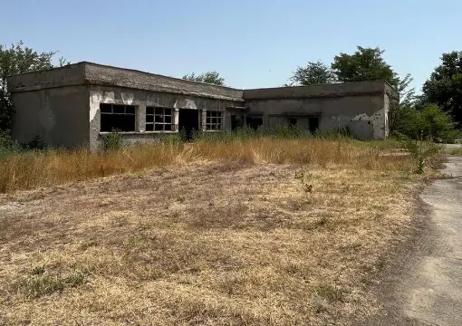 Ruins of a camp building in the long grass
