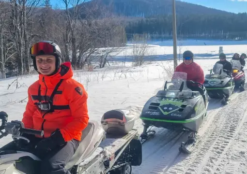 Smiling rider in a helmet before the snowmobile ride