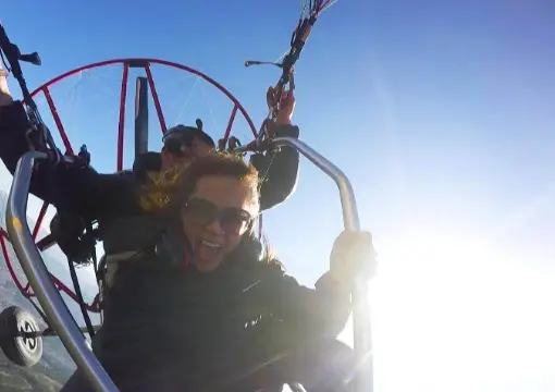 Smiling guest in the motor paraglider trike in the morning sun