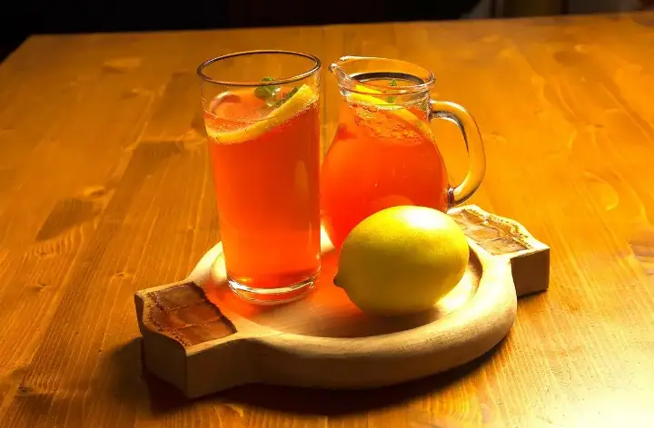 Warm drinks with lemon on a wooden board
